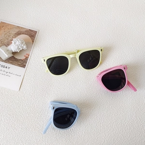 Flat lay of portable foldable children's sunglasses in beige, pink, and blue shades