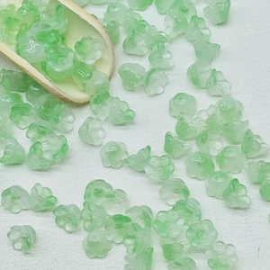 Detail of light green frosted lily of the valley glass beads on a white background