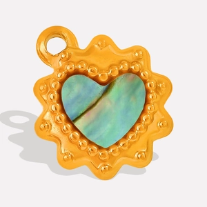 Macro detail of heart pendant with gold beaded frame and iridescent shell inlay