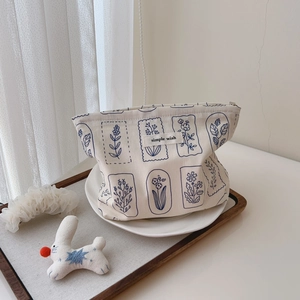 Floral canvas makeup bag with blue botanical print and Simple Wish label on beige fabric