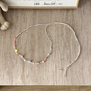 Close-up of bohemian braided belt with colorful beads and natural tassels on stone