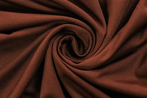 Close-up of deep brown high-elasticity knit fabric with elegant draping and fine texture