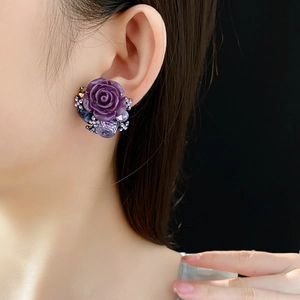 Detail view of a vintage purple rose earring with sparkling crystals on a model