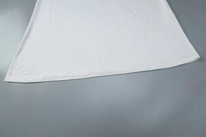 Gros plan sur l'ourlet et la texture du tissu blanc doux d'une robe moulante