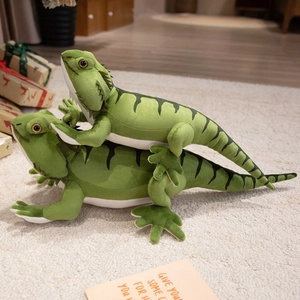 Set of two green bearded dragon plush toys with black stripes on a soft home carpet
