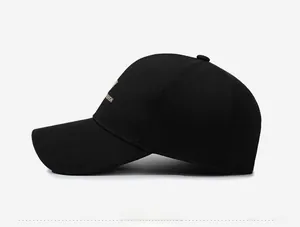 Detail of gold Fashion embroidery on the side of a black cotton baseball cap