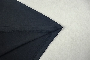 Detailed close-up of double-stitched seams on high-density black knit fabric