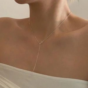 Close-up of minimalist S925 sterling silver Y-shaped tassel necklace on model neck