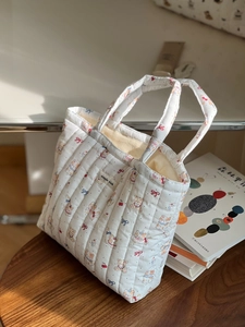 Close-up of a white quilted cotton tote bag with cute bear and cherry patterns