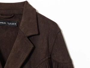 Detail of dark brown faux suede jacket featuring fringe decoration and collar texture