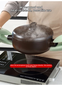 Close-up of shark-shaped silicone oven mitts lifting a hot ceramic pot with steam