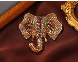 Detailed close-up of elephant brooch with colorful rhinestones on dark fabric
