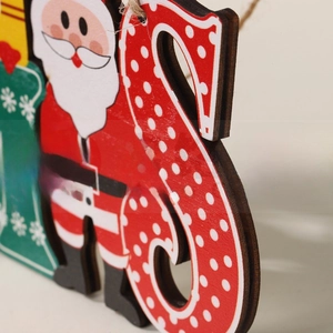 Macro shot of festive wooden Christmas hanging sign with Santa and stocking details