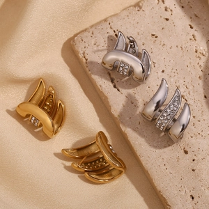 Detailed view of 18K gold and silver stacked stud earrings with micro-set zircon stones