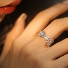 Close-up of a silver ring featuring a pavé-set round face and tapered textured band