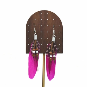 Close-up of Bohemian long tassel feather earrings with magenta feathers and beads
