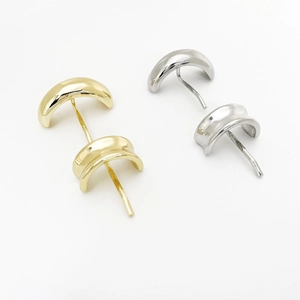 Detailed view of curved gold and silver metallic stud earrings with polished finish