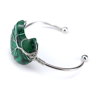 Detail of silver wire-wrapped tree of life design on crescent moon green stone bangle