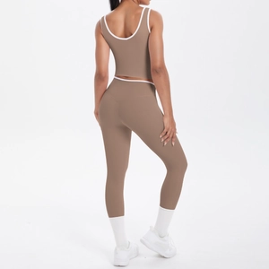 Detail of high-waisted yoga leggings and sports bra with white contrast piping in mocha
