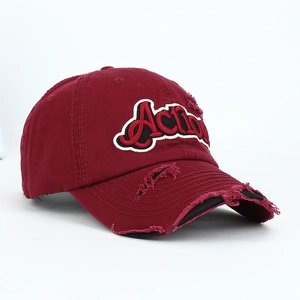 Close-up of distressed vintage wine red baseball cap with embroidered Action logo