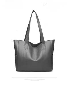Detail view of large grey faux leather wing tote bag showing side pockets and stitching