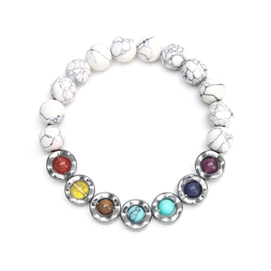 White turquoise beaded chakra bracelet with seven colorful gemstones on white background