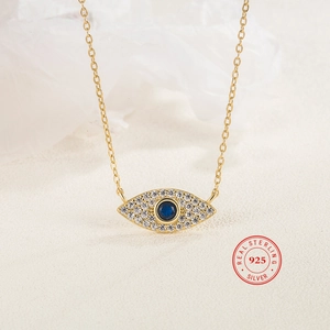 Macro shot of 925 sterling silver evil eye pendant with blue zircon and white crystals