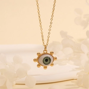 Detailed macro view of 18K gold-plated Evil Eye pendant necklace with green center stone