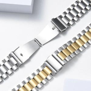 Macro shot of silver and two-tone stainless steel three-link watch bands with butterfly clasp