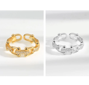 Close-up of gold and silver chain rings showing 925 hallmarks and sparkling pavé details