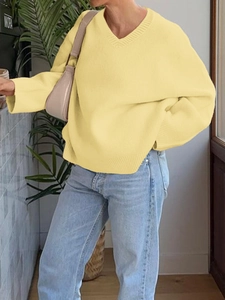 Close-up of light yellow V-neck knitted sweater with soft texture and loose fit