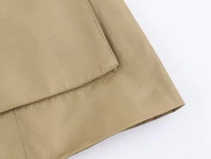 Nahaufnahme der khakifarbenen Köperstoff-Textur und der Taschennaht an der Damenjacke