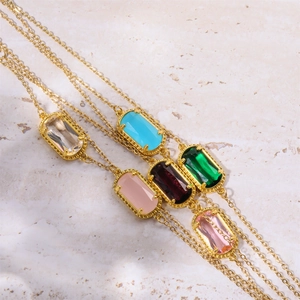 Makroaufnahme verschiedener bunter ovaler Edelsteine an eleganten goldenen Halsketten