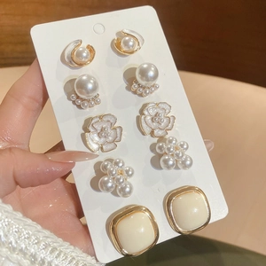 Detail of 5-piece earring set featuring pearls and flower designs on a card display