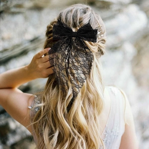 Detailed view of elegant black lace bow hair clip with floral embroidery long ribbons