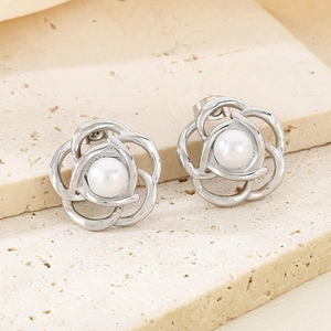 Macro detail of silver floral petal earrings with a lustrous white pearl center