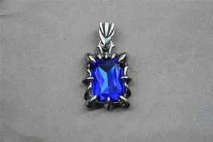 Detail of vintage dragon claw pendant with large rectangular blue gemstone and silver finish