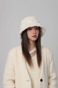 Detail of off-white plush bucket hat with subtle plaid texture on fashion model