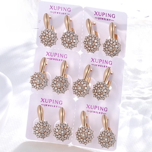 Close-up of six pairs of gold-plated cluster stud earrings featuring sparkling round zircons