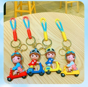 Detailed view of four colorful PVC cartoon scooter keychains on a wooden background