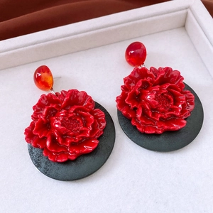 Detail of vintage 3D red flower earrings with floral texture and contrast beads
