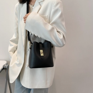 Chic black bucket handbag for women with gold hardware and adjustable strap on model