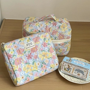 Quilted floral cosmetic bag set featuring a soft macaron pattern on a wooden surface