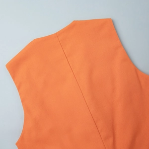 Close-up of the orange linen vest showing rear seam stitching and high-quality texture