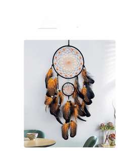 Detail of hand-woven dual-ring dream catcher with black and orange feathers