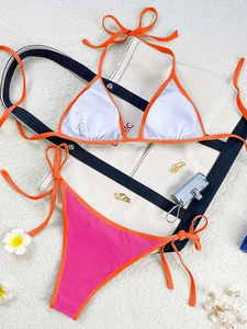 Close-up of vibrant orange halter bikini top with wash label and textured fabric details
