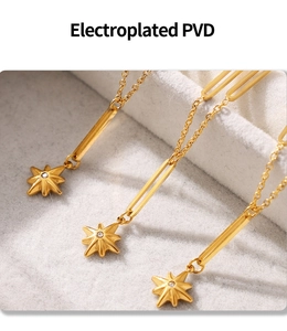 Macro detail of PVD plated gold star necklace showing zircon inlay and polished link texture