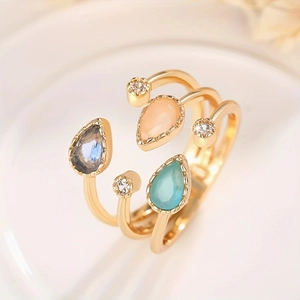 Detail of three-tier gold ring with colorful water drop gemstones and zircon accents
