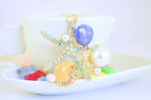 Close-up of ocean-themed starfish keychain with blue shell and colorful rhinestones