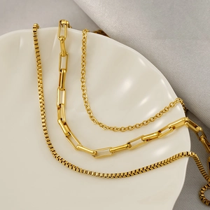 Close-up of golden stainless steel triple necklace set with paperclip and box chains